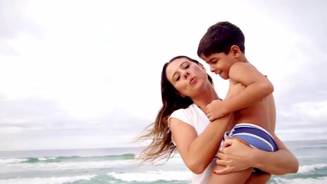 Mother holds her son on a beach in Brazil