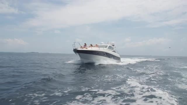 Young Women Sun Bathing On Deck Of Luxurious Boat