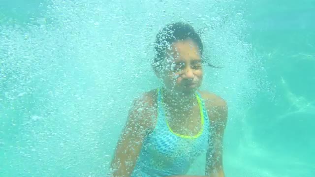 Young Hispanic Girl jumps into a pool