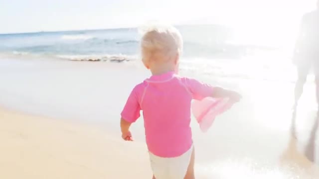 Blonde mother and baby on a beach