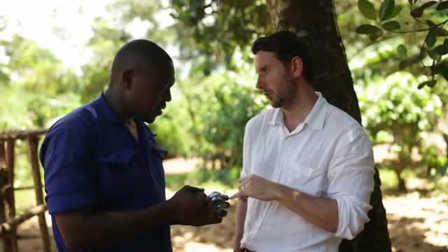 A caucasian man chatting to African mechanic about the installation of a new well in the village 