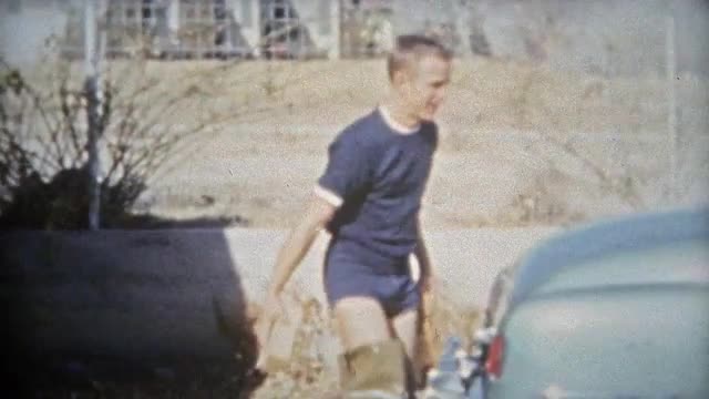 HOUSTON, TEXAS 1953: Young athletic teenager washing car in thigh boots.