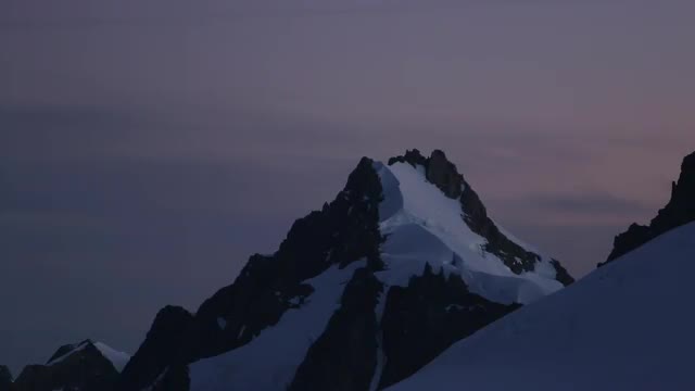 Footage of the sunrise over mountain peaks near Fox Glacier in New Zealand