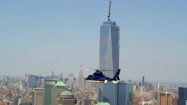 AERIAL TRACKING SHOT helicopter flies past One World Trade Center with ZOOM IN to CLOSE UP then ZOOM