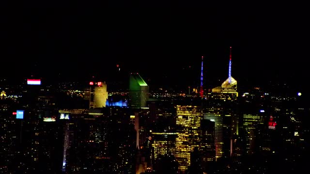 LONG AERIAL Midtown Manhattan with fireworks in Queens in background