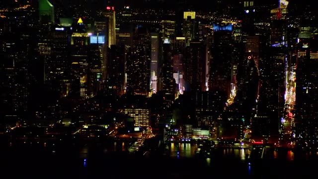 AERIAL Midtown Manhattan with fireworks in Queens in background