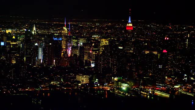 LONG AERIAL Midtown Manhattan with fireworks in Queens in background