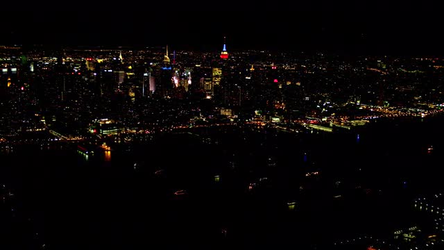 LONG AERIAL Midtown Manhattan with Hudson River in foreground at night