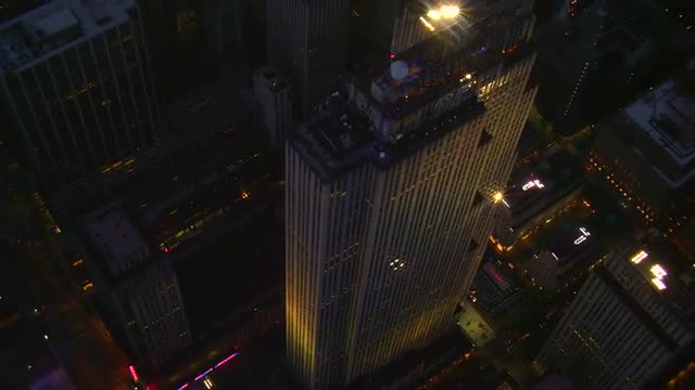 CLOSE UP AERIAL around Rockefeller Center at night