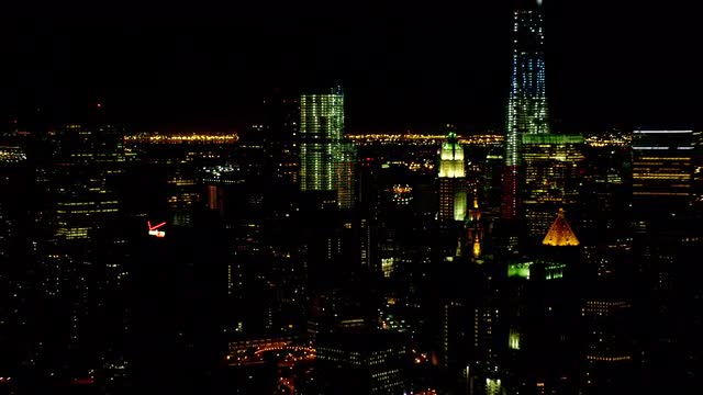 MEDIUM to WIDE AERIAL buildings in Lower Manhattan at night