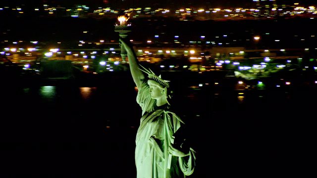 MEDIUM AERIAL around Statue of Liberty at night