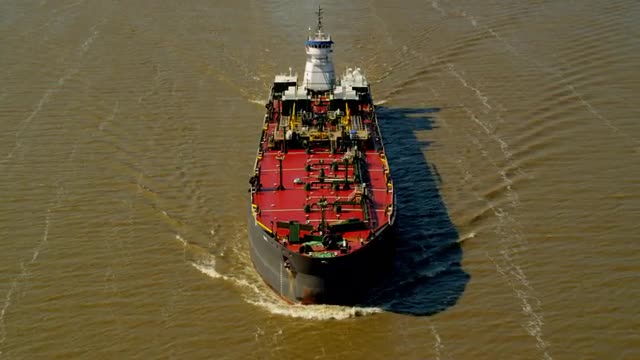 AERIAL POV toward and over ship on Hudson River with bridge in background