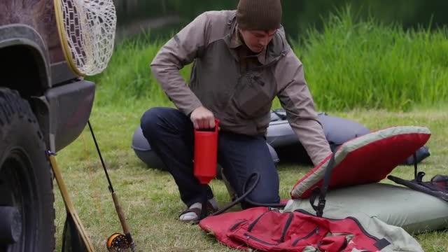 Fly fisherman pumping up float tube