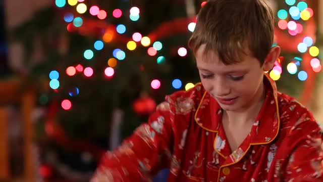 Boy opening Christmas gift and get surprise