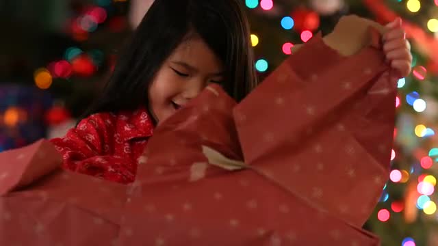 Young girl opens opens Christmas present