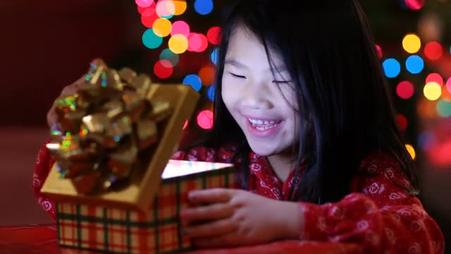 Young girl opens opens Christmas present