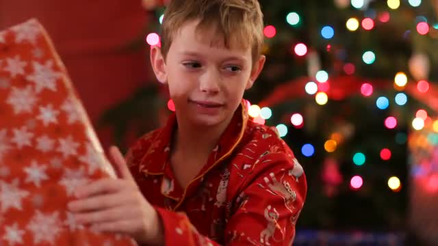 Boy shaking and listening to Christmas gift