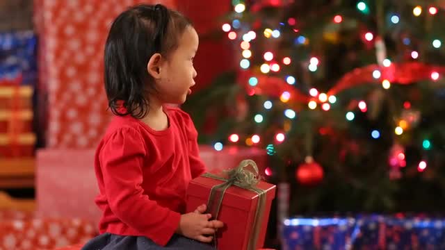 Young girl shaking Christmas gift