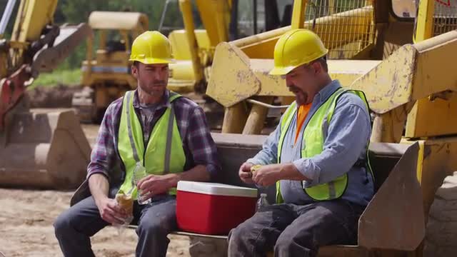 Two blue collar workers having lunch on job site