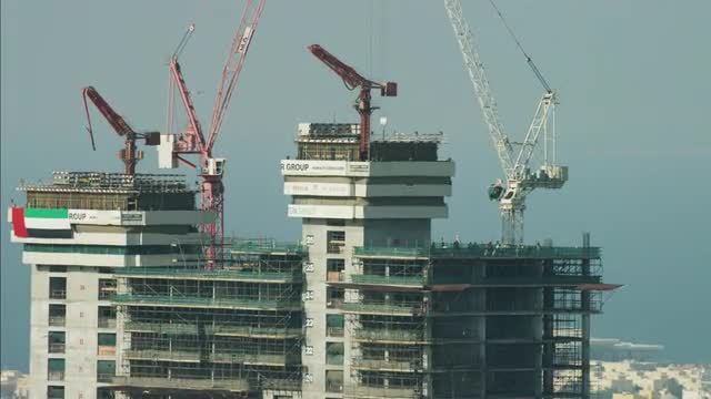 Aerial Dubai Construction workers highrise building cranes UAE