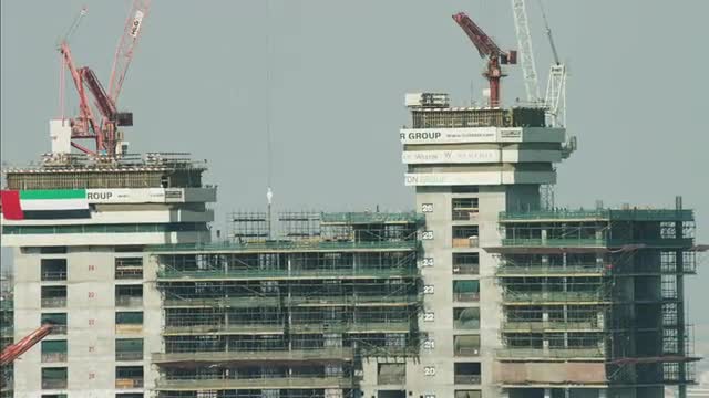 Aerial Dubai Construction workers highrise building cranes UAE