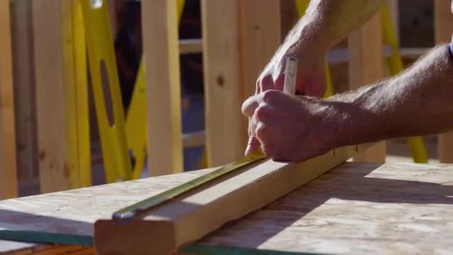 Closeup of construction worker measuring board