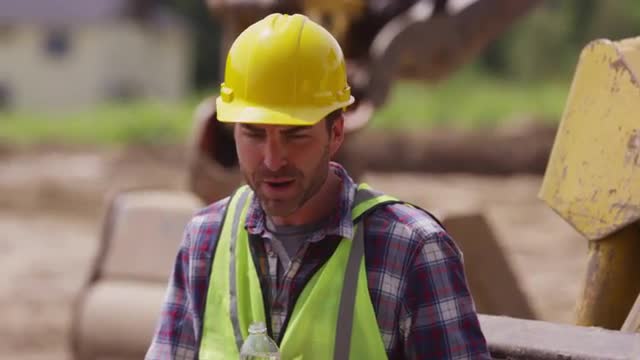 Two blue collar workers having lunch on job site