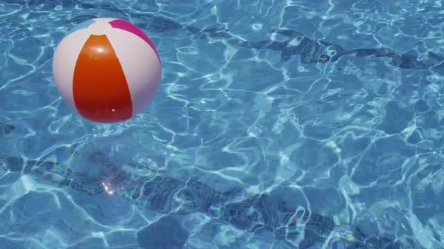 Colorful beach ball floating in pool. Shot on RED EPIC for high quality 4K, UHD, Ultra HD resolution