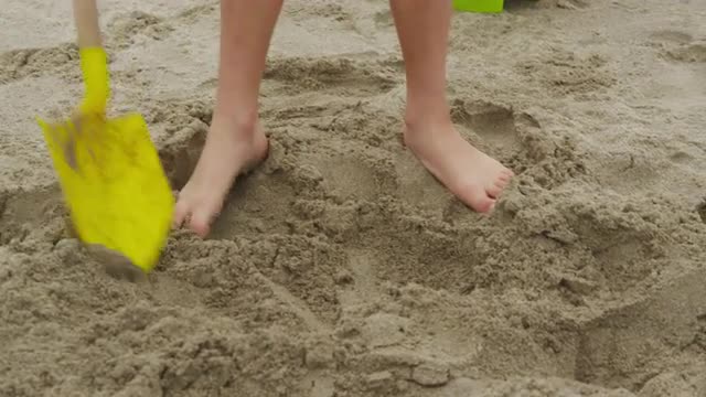 Child digging in sand at beach. Shot on RED EPIC for high quality 4K, UHD, Ultra HD resolution.