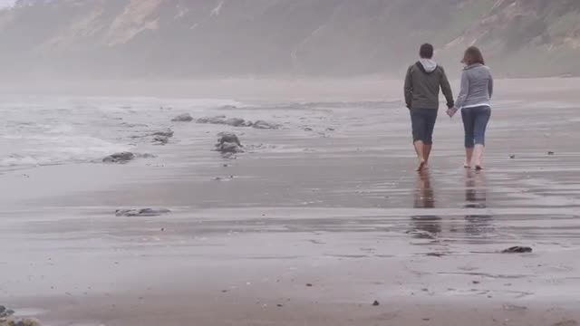Couple walking at beach together. Shot on RED EPIC for high quality 4K, UHD, Ultra HD resolution.