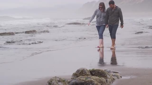 Couple walking at beach together. Shot on RED EPIC for high quality 4K, UHD, Ultra HD resolution.