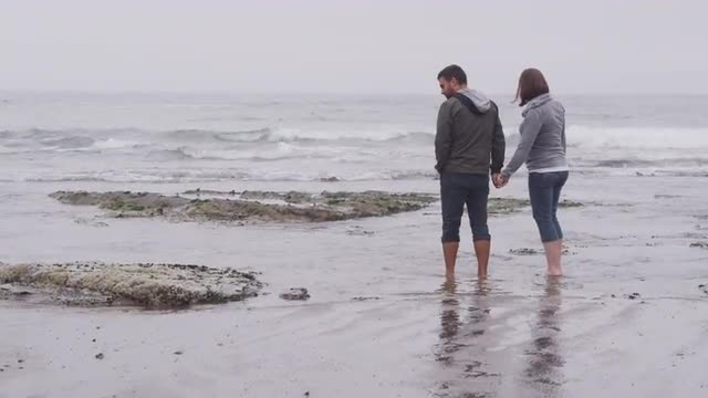 Couple walking at beach together. Shot on RED EPIC for high quality 4K, UHD, Ultra HD resolution.