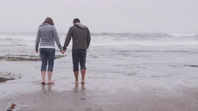 Couple walking at beach together. Shot on RED EPIC for high quality 4K, UHD, Ultra HD resolution.
