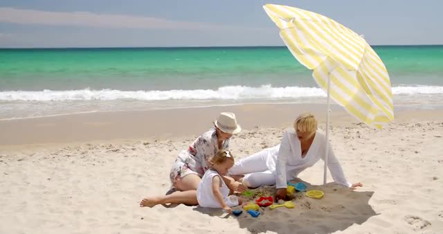 Grandma  Mom and Little Girl Playing at Beach Sand