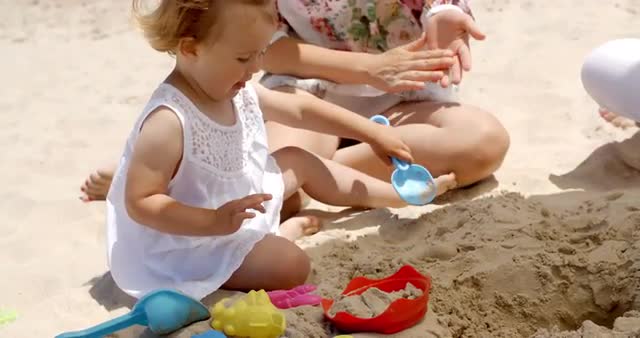Little Girl Playing with Sand Toys at the Beach