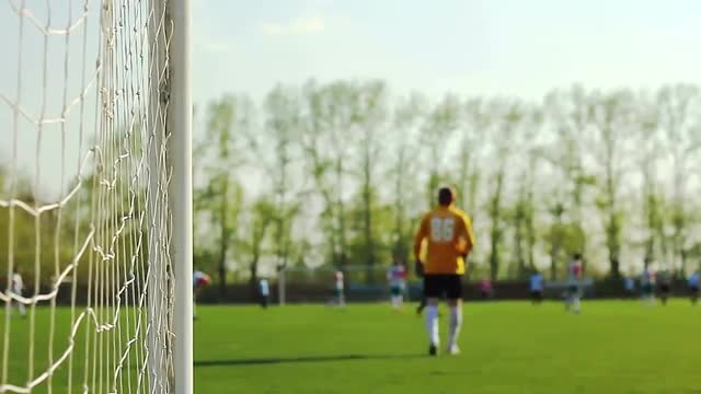 Goalkeeper and players running around on a football field