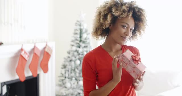 Smiling African woman holding a Christmas gift