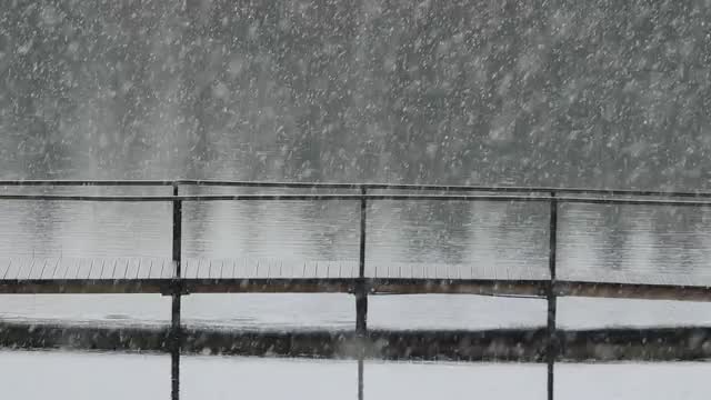 Thick snowfall over a lake