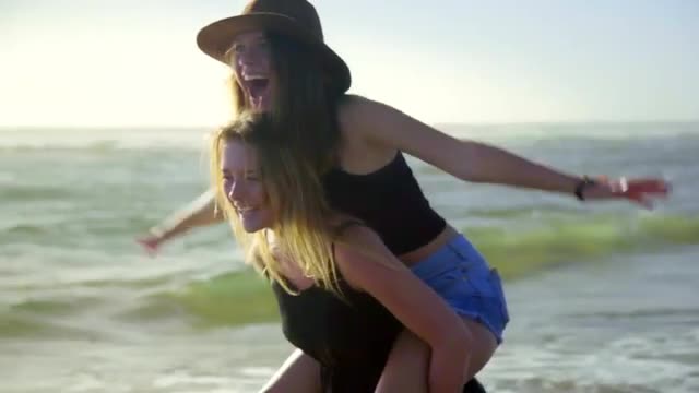 Girl gives friend a piggyback ride 