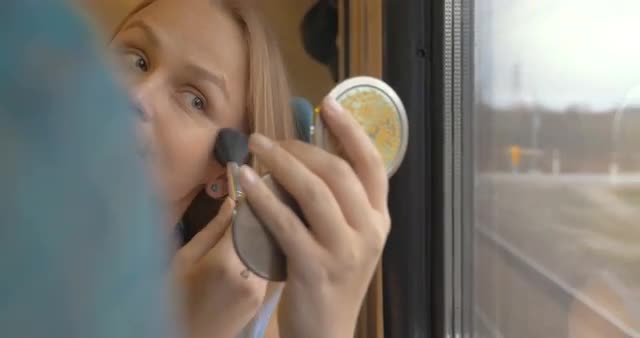Woman going by train and putting on make-up