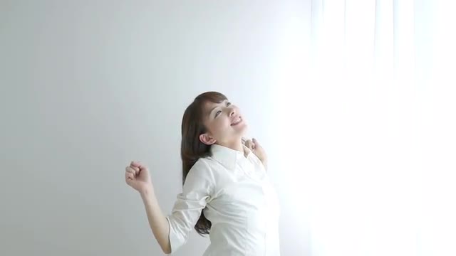 A Japanese woman stretching in front of curtain