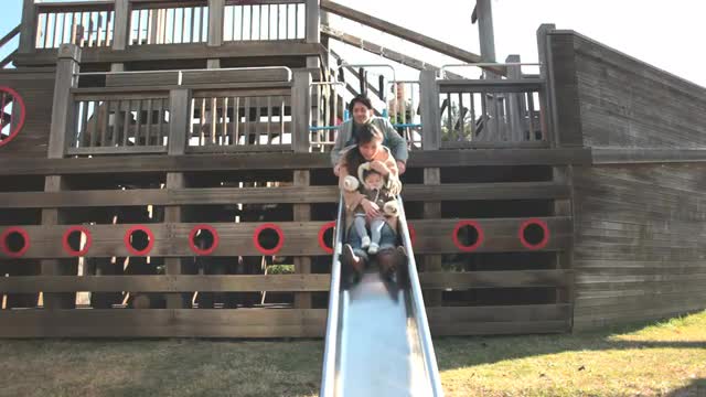 A family playing on a sliding