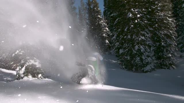 Slow motion snowmobile jumping in powder snow
