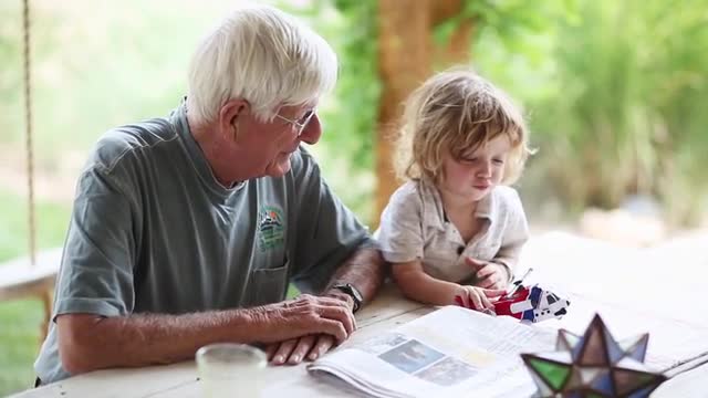 Caucasian grandfather and grandson playing at table
