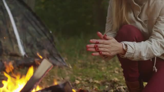 38_43_15_Blond_girl_warming_hands_near_Campfire