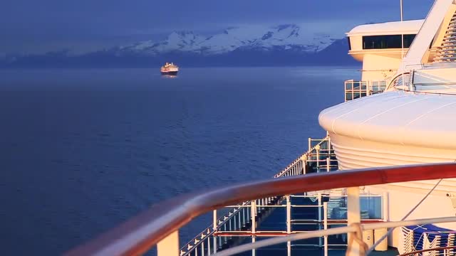 Morning sun lights side of cruise ship second cruise ship following in Alaska inside passage