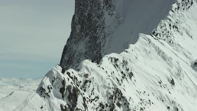 Aerial shot of skiers standing on mountain spine
