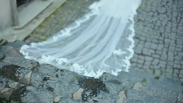 Beautiful Bride with Long Veil Down the Stairs of Stone