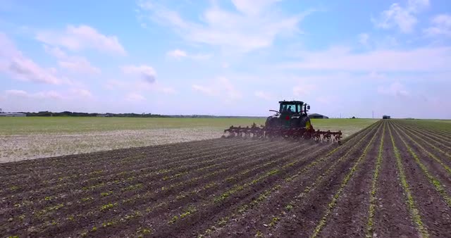 Aerial of tractor plowing farm