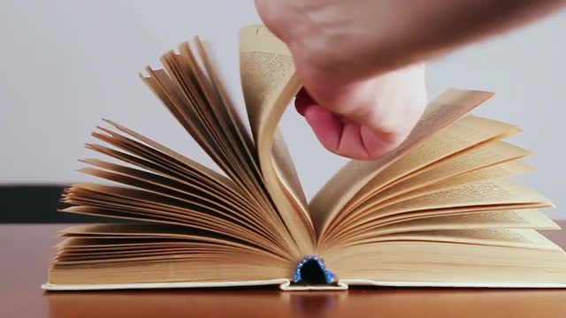 The Man Flips Through an Old Book. Slow Motion.
